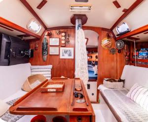 a living room with a table in a boat at Paraty em um veleiro passeio diário in Paraty
