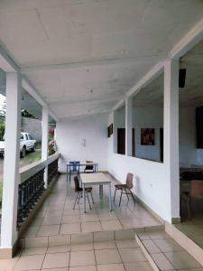 a patio with a table and chairs on a building at Peckers Mountain Climbers in Buea