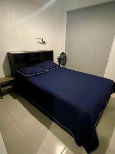 a bedroom with a large bed with a blue comforter at Casa Vacacional Maya in Comitán de Domínguez