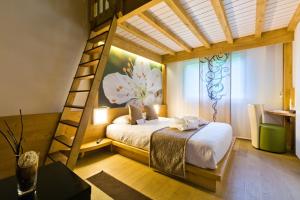 1 dormitorio con cama elevada y escalera en La Croix de Savoie & Spa, en Les Carroz d'Araches