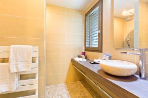 een badkamer met een wastafel en een spiegel bij La Croix de Savoie & Spa in Les Carroz d'Araches