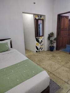 1 dormitorio con cama, espejo y puerta en Yali homestay, en Kuilapayam