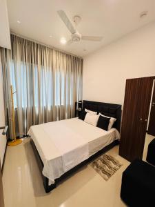 a bedroom with a bed and a ceiling fan at Trizen luxury apartments Colombo Sri lanka in Colombo
