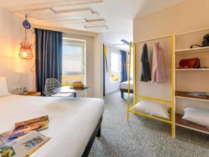 a hotel room with a large bed and a room with at ibis styles La Rochelle Thalasso Chatelaillon in Châtelaillon-Plage