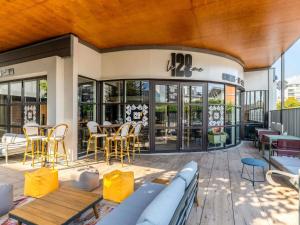a patio with a couch and tables and chairs at ibis Le Havre Centre in Le Havre