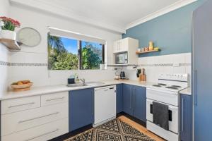 una cocina con electrodomésticos azules y blancos y una ventana en Hawaiian Gardens 2, en Coffs Harbour