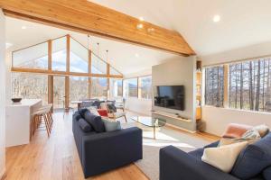 ein Wohnzimmer mit Sofas und einem Flachbildfernseher in der Unterkunft Inari Chalet in Niseko