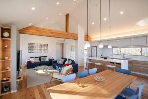 eine Küche und ein Wohnzimmer mit einem Tisch und einer Couch in der Unterkunft Inari Chalet in Niseko