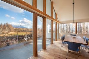 ein Esszimmer mit einem Tisch und Bergblick in der Unterkunft Inari Chalet in Niseko