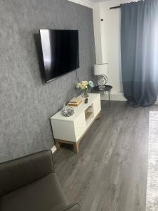 a living room with a tv on a wall at The Cosy Haven - 2 Bedroom house in Manchester +8 photos