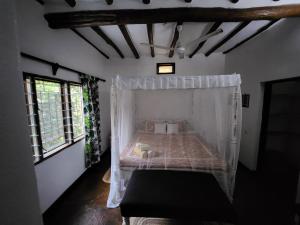 a bedroom with a bed with a mosquito net at Villa Fortuna Malindi in Malindi