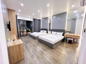 a hotel room with two beds and a desk at La Mer Hostel in Cat Ba
