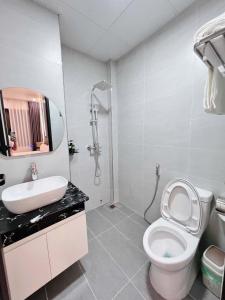 a bathroom with a toilet and a sink and a shower at La Mer Hostel in Cat Ba