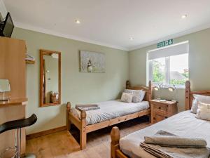 a bedroom with two beds and a mirror at 1 Bed in Brundall 46293 in Brundall