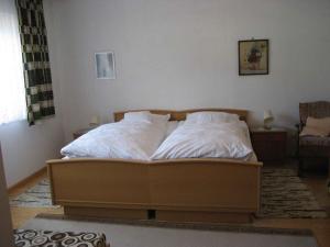 ein Bett mit weißer Bettwäsche und Kissen in einem Schlafzimmer in der Unterkunft Ferienwohnung King in Triberg