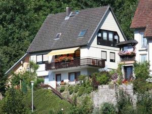 ein großes weißes Haus mit Balkon auf einem Hügel in der Unterkunft Ferienwohnung King in Triberg