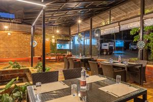 a restaurant with tables and chairs in a room at Sterling Kadumane Hills Sakleshpur in Sakleshpur