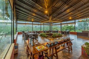 a large room with tables and chairs and windows at Sterling Kadumane Hills Sakleshpur in Sakleshpur +43 photos