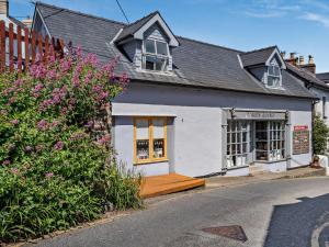 a white building with a wooden porch on a street at 1 Bed in New Quay 45927 in New Quay