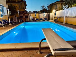 una piscina con un banco frente a ella en MIU' Bed and Breakfast, en Ciampino