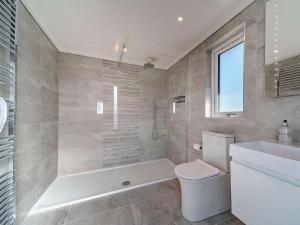 a bathroom with a tub and a toilet and a sink at 1 Bed in Langbank 95823 in Langbank +7 photos