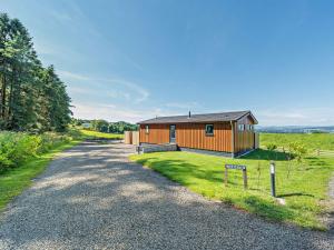 a house on a gravel road next to a field at 1 Bed in Langbank 95823 in Langbank