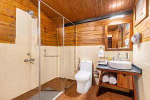 a bathroom with a toilet and a sink at Sterling Kadumane Hills Sakleshpur in Sakleshpur