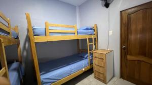 Habitación con 2 literas y puerta de madera. en Alojamiento en Shekinah House, en Data de Villamil 8 fotos más
