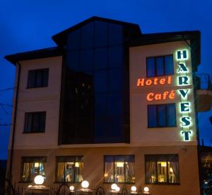 a large building with a neon sign on the front of it at Harvest in Vinnytsya