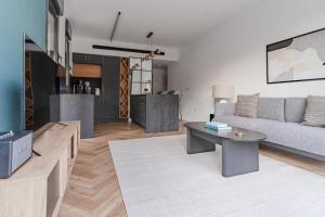 a living room with a couch and a table at Blueground at Ramat HaHayal, Garden view, Balcony in Tel Aviv