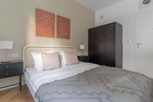 a bedroom with a large white bed with two pillows at Blueground at Ramat HaHayal, Garden view, Balcony in Tel Aviv