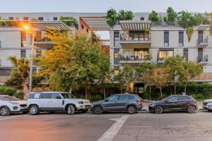 a group of cars parked in a parking lot at Blueground at Ramat HaHayal, Garden view, Balcony in Tel Aviv