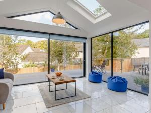 a living room with large windows and a couch at 4 Bed in Bude 89355 in Poughill