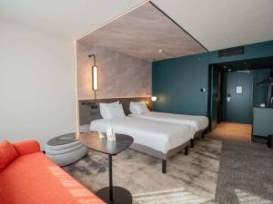 a hotel room with two beds and a couch at Novotel Rotterdam Brainpark in Rotterdam +103 photos