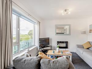 a living room with a couch and a large window at 2 Bed in Brixham BX079 in Brixham