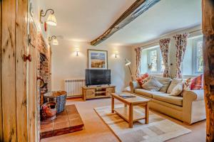 un salon avec un canapé et une télévision dans l'établissement Bourne Cottage, à Weybourne