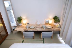 une pièce avec une table en bois avec des chaises et des lumières dans l'établissement Fukuoka Hakata Stay 1BR with Balcony, TV and Laundry, à Fukuoka