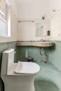 a bathroom with a toilet and a sink at The sunrise Himalayas view cottage in Bhowāli