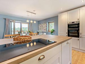 a kitchen with blue walls and a large kitchen island at 4 Bed in Kippford 95234 in Kippford