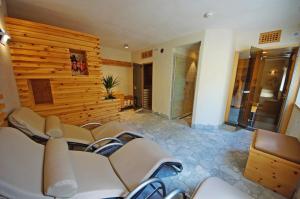a conference room with white chairs and a wooden wall at Pension Arnica B&B in San Vigilio Di Marebbe