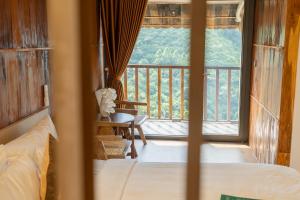 Un dormitorio con una cama y vista a un balcón. en Gia Trang Heian Hoa Binh, en Hòa Bình