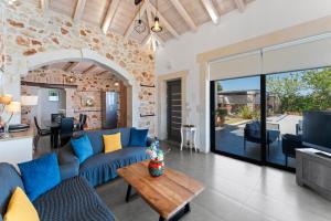 Una sala de estar con un sofá azul y una mesa. en Villa Resi, en Vamos