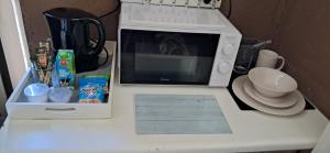 a microwave sitting on top of a white counter at Clay Stone Cottage in Goodwood