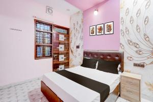 a bedroom with a bed in a room with pink walls at Hotel O Ocean's 11 in Daurāla