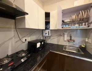 una cocina con microondas y estufa horno superior en The prestige hotel,  13 fotos más