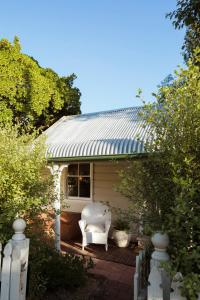 a white chair sitting on the porch of a house at Illalangi Boutique Cottage in Blackheath