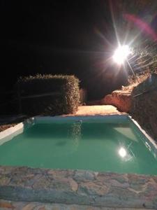 ein Schwimmbad in der Nacht mit Licht in der Unterkunft Alojamiento Rural el Nolo in Chincolla