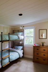 a bedroom with two bunk beds and a window at Illalangi Boutique Cottage in Blackheath