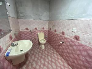 a pink bathroom with a sink and a toilet at Villa Ceylonra in Tangalle