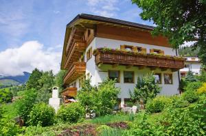 a house with a balcony with flowers on it at Pension Arnica B&B in San Vigilio Di Marebbe